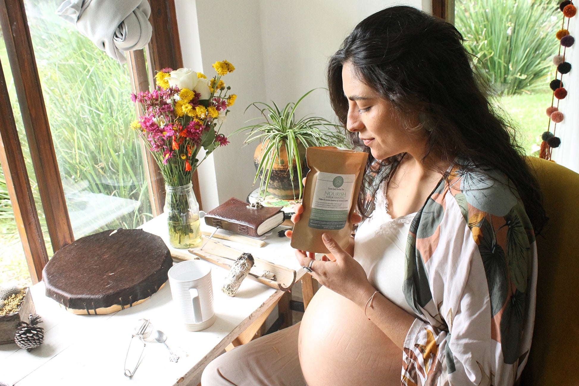 woman smelling an open bag of herbal tea